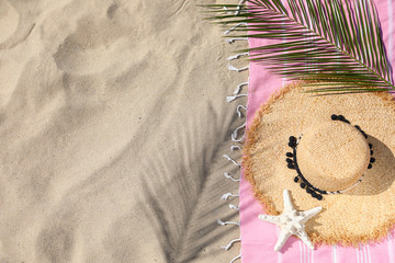 Fototapeta na wymiar Flat lay composition with beach accessories on sand. Space for text