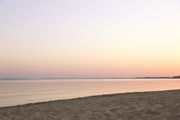 Sandy beach near sea at summer sunset