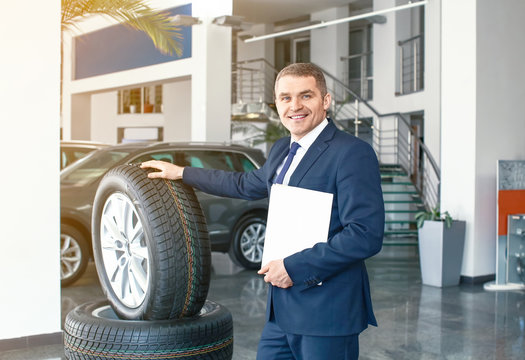 Salesman In Modern Car Showroom