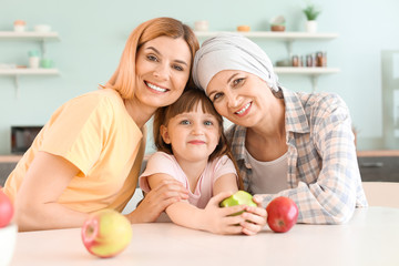 Fototapeta na wymiar Mature woman after chemotherapy with her family in kitchen at home