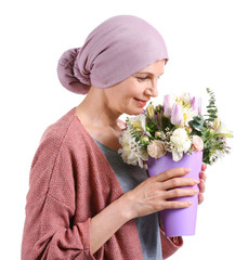 Mature woman after chemotherapy with bouquet of flowers on white background