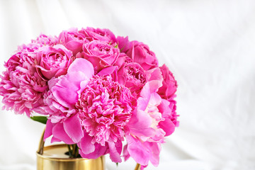 Watering can with beautiful peonies on white background