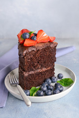 Plate with piece of tasty chocolate cake on table