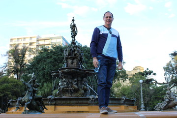 man sitting on bench in front of an old building