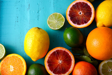 Citrus Fruit on vintage aqua distressed wood table, including navel and blood oranges, lemons and...