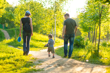 Obraz premium Portrait of Young Caucasian Family of Three Together Outdoors. Having a Stroll.