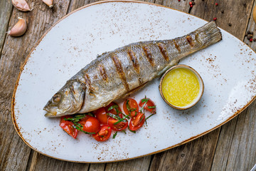 Fried sea bass on wooden background