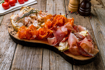 slicing of different meat bacon, jamon, parma, chorizo on the board