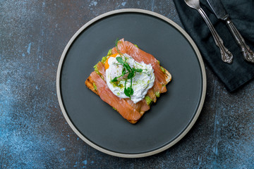 poached egg with salmon and avocado on a white plate