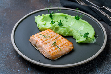 Salmon steak on the grill with green mashed beens