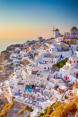 Cityscape of Oia Village in Santorini Island Located on Red Volcanic Caldera Before Sunset. - obrazy, fototapety, plakaty