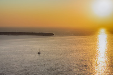 Lonely Romantic Sailing Boat on Sunset Near Santorini Island in Greece.