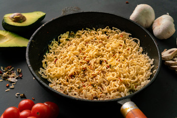 top view of ingredients for cooking pasta on the table, avocado, noodles in the pan, mushroom