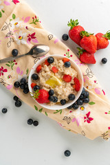healthy breakfast with oatmeal porridge with starwberry and blueberry in a bowls