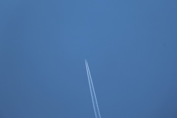 Flugzeug mit weißem Kondensstreifen am klaren blauen Himmel, Raum für Text
