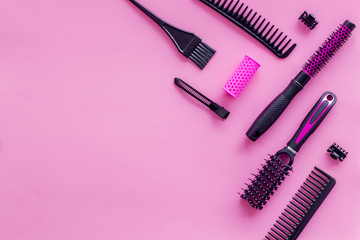 Combs and hairdresser tools in beauty salon work desk on pink background top view mockup
