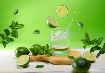 Refreshing lime and mint drink with ice , photo manipulation lime and ice falling into the glass of...