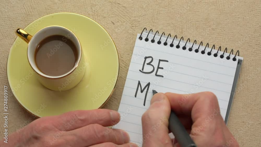 Canvas Prints be mindful - man hand writing a note with a black marker in a spiral notebook, overhead view