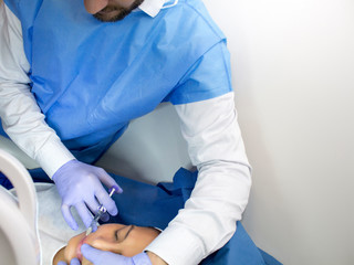 Doctor doing a skin treatment to a patient in his office