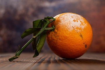 side view overripe orange on a wood table