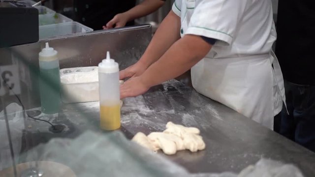 Making dough hand pulled noodles, repeatedly stretch dough to produce long thin strands.