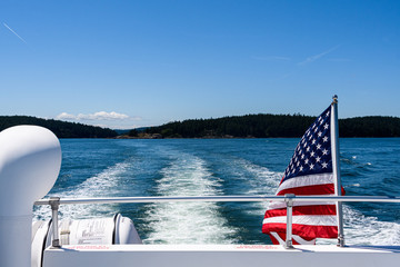 Symbol of freedom, American flag flying on the back of a boat cruising in the Salish Sea of the San...