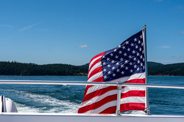 Symbol of freedom, American flag flying on the back of a boat cruising in the Salish Sea of the San...