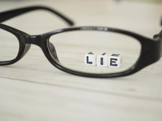 眼鏡のレンズを通して見えるLIEの単語