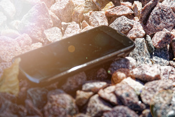 Broken cellphone abandoned and lost among the gravel