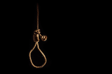 Fototapeta na wymiar Noose of braided rope on a gloomy dark background, failure or suicide concept