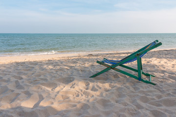 Fototapeta na wymiar empty wooden beach chair at the beach
