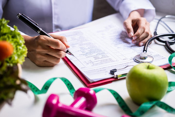 Nutritionist with healthy fruit, vegetable and measuring tape working, Right nutrition and diet...