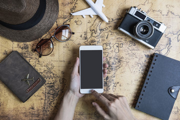 Retro camera with toy plane and smartphone on old world map background with copy space, Travel concept