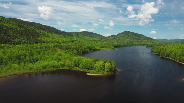 Flying above a peninsula sticking out in to the Penobscot River with vibrant spring colors AERIAL