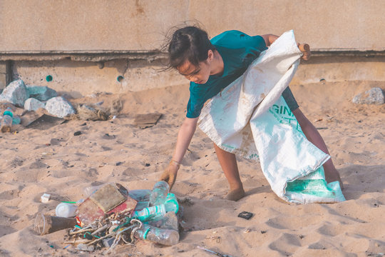 Children is picking up Plastic bottle and gabbage that they found on the beach for enviromental clean up concept
