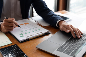 Obraz premium Businessmen, finance, accounting work, checking accounts, using calculators and finding information
