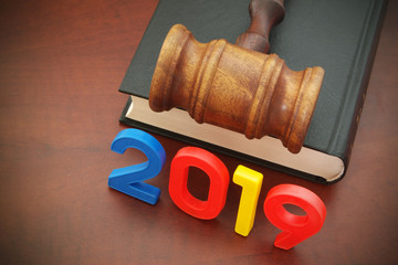 Numbers 2019 and wooden judge gavel on legal book as symbol of new laws of 2019