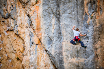 Man climbs rock.