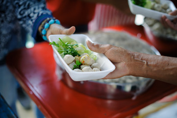 volunteers giving food to poor people in desperate need : The concept of food sharing Help solve Hunger for the homeless