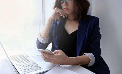 beautiful young business woman working in the office or home with paperwork calculator laptop and computer.