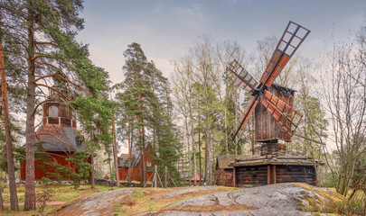 Kirche wooden church and windmill in the open air park museum in Helsinki Finland in the spring...