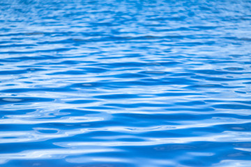 Naklejka premium Water surface. Background image. The concept of recreation at the sea, by the river or lake. Shades of blue, minimalism. The texture of the water surface.