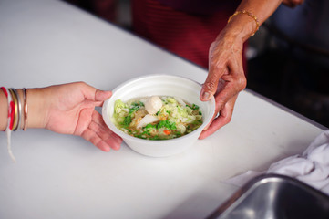 The hands of refugees have been aided by charity food to alleviate hunger : Feeding Concepts : Hand offered to donate food from a rich man Share : The concept of social sharing