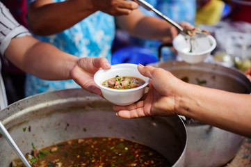 The concept of humanitarianism : The hands of refugees have been aided by charity food to alleviate...
