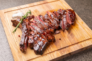 food, delicious and craft concept - cutting horse meat steak on wooden desk