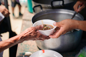 The Hand of the Beggars receives charity food from fellow human beings : The concept of humanitarianism : The hands of refugees have been aided by charity food to alleviate hunger : Feeding Concepts