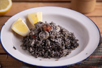 Plate of black rice with squid and prawns or Valencian black paella
