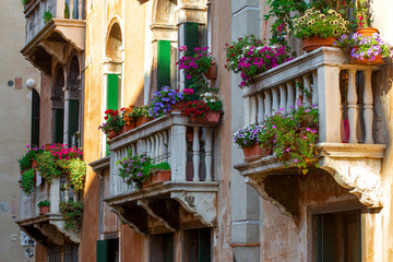 Beautiful building facade with flowers pots in Venice, Italy. Summer cityscape