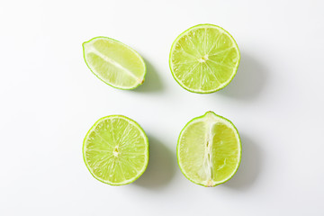 Flat lay composition with limes on white background, space for text