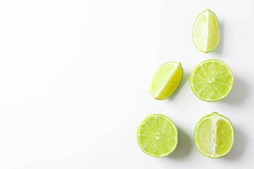 Flat lay composition with limes on white background, space for text